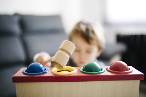 Little boy playing with wooden motor skill toy, close-up - JRFF000206