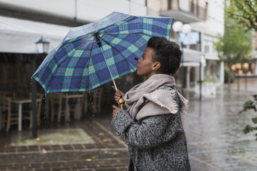 Italien, Grado, Frau hält Regenschirm an einem regnerischen Tag im Herbst - MAUF000057