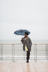 Italien, Grado, Frau mit Regenschirm vor dem Meer stehend - MAUF000065