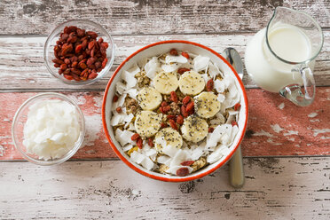 Bowl of muesli with banana slices, chia seeds, coconut chips and goji berries - SARF002329