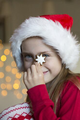 Girl with Christmas cap holding cinnamon star - SARF002336