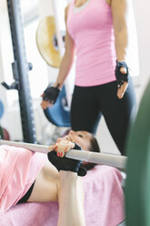 Zwei Frauen beim Langhantelbankdrücken in einem Power Rack - MADF000733