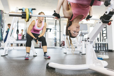 Frau macht gewichtete Rückenstrecker im Fitnessstudio - MADF000746