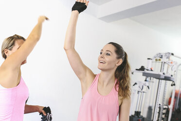 Zwei Frauen geben sich nach dem Training im Fitnessstudio die Hand - MADF000754