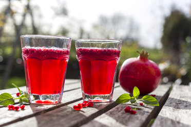 Granatapfelsirup mit Granatapfelkernen, Prosecco und Mineralwasser im Glas - SARF002340