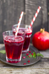 Pomegranate sirup with pomegranate seeds, prosecco and mineral water in glasses - SARF002343