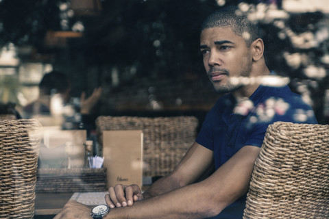 Mann in einem Cafe hinter Fensterscheibe, lizenzfreies Stockfoto