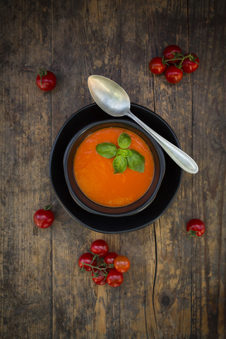 Schüssel mit Tomatencremesuppe, garniert mit Basilikumblättern, lizenzfreies Stockfoto