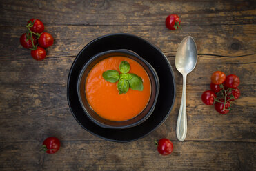 Schale mit Tomatencremesuppe, garniert mit Basilikumblättern auf Holz - LVF004205