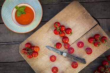 Schüssel mit Tomatencremesuppe und Schneidebrett mit ganzen und geschnittenen Tomaten - LVF004210