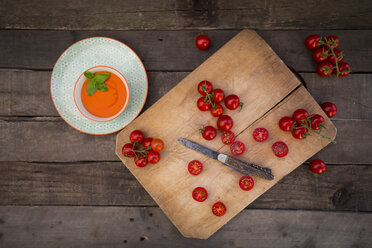 Bowl of tomato cream soup and chopping board with whole and sliced tomatoes - LVF004212