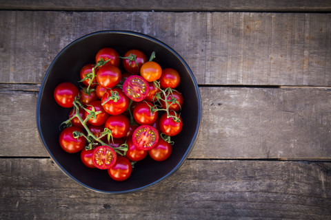 Schale mit Tomaten auf Holz, lizenzfreies Stockfoto