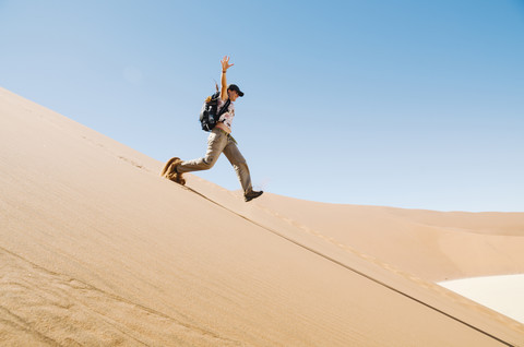 Namibia, Namib Desert, woman running down a dune stock photo