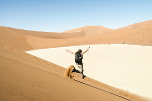Namibia, Namib-Wüste, Frau läuft eine Düne hinunter auf dem Weg zum Deadvlei - GEMF000510
