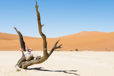 Namibia, Namib-Wüste, Frau ruht in totem Baum in Deadvlei - GEMF000521