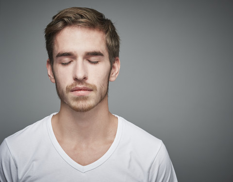 Porträt eines jungen Mannes mit geschlossenen Augen, lizenzfreies Stockfoto