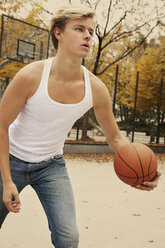 Junger Mann spielt Basketball im Freien - TMF000078