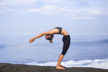 Indonesien, Bali, Frau übt Yoga an der Küste - KNTF000191