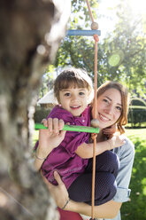 Mutter mit Tochter auf Strickleiter im Garten - FKF001624