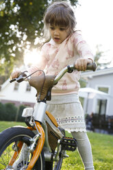 Mädchen auf Fahrrad im Garten - FKF001658