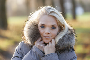 Porträt einer lächelnden jungen blonden Frau im Herbst - TCF004930