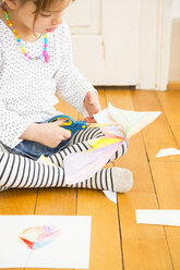 Kleines Mädchen bastelt mit Papier und Schere - LVF004223