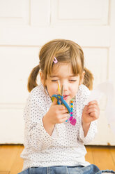 Little girl with piece of paper and scissors - LVF004224