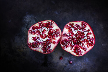 Two halves of a pomegranate on dark ground - KSWF001685