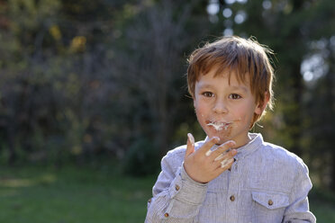 Porträt eines glücklichen Jungen, der Süßigkeiten isst - LBF001295