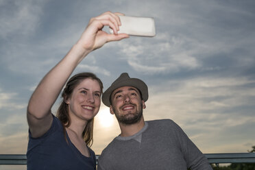 Lächelndes junges Paar macht ein Selfie mit Smartphone - PAF001499