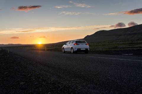 Island, Auto auf der Straße unter der Mitternachtssonne, lizenzfreies Stockfoto