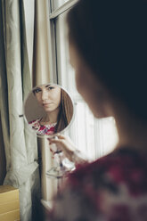 Young woman looking in hand mirror - MAUF000124