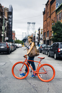 USA, New York City, Williamsburg, Frau mit rotem Rennrad beim Überqueren der Straße - GIOF000578