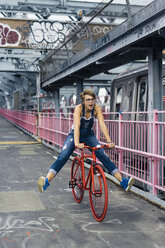 USA, New York City, Williamsburg, Frau mit rotem Rennrad auf der Williamsburg Bridge - GIOF000584