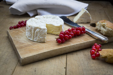 Camembert, Brot und rote Johannisbeeren auf Holz - LVF004239