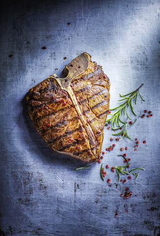 T-Bone-Steak, roter Pfeffer und Rosmarin, lizenzfreies Stockfoto