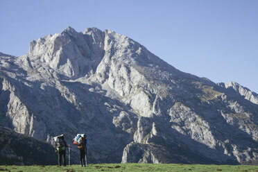 Spanien, Picos de Europa, zwei Wanderer mit Berglandschaft im Hintergrund - ABZF000157