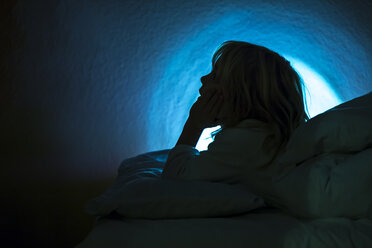 Silhouette of little girl lying in bed - JFEF000758