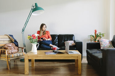 Young woman relaxing on the couch in her living room - BOYF000017