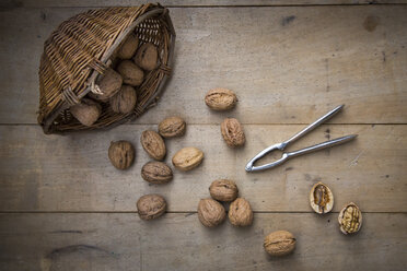 Wickerbasket, walnuts and nutcracker on wood - LVF004255