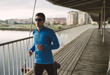 Spain, Naron, jogger running on a wooden bridge - RAEF000697