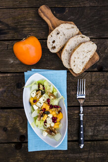 Herbstlicher Salat mit Kaki, Feta-Käse, Eisbergsalat, Kürbiskernen, Granatapfel und Walnüssen - SARF002389