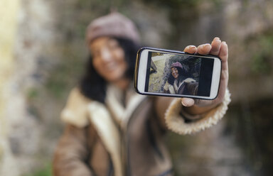 Selfie of smiling woman on display of smartphone - MGOF001134