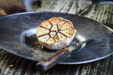 Gerösteter Knoblauch auf Teller, Messer - SBDF002511