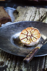 Gerösteter Knoblauch auf Teller, Messer - SBDF002512