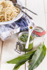 Fresh ramson pesto with plate of spaghetti in background - SBDF002535