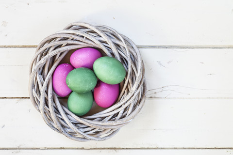 Grüne und rosa Ostereier im Nest, lizenzfreies Stockfoto