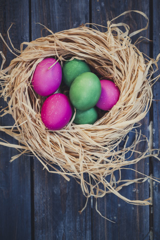 Grüne und rosa Ostereier im Nest, lizenzfreies Stockfoto