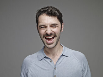 Portrait of screaming man in front of grey background - RH001071