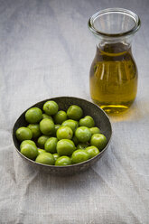 Schale mit grünen Oliven und Karaffe mit Olivenöl - LVF004276